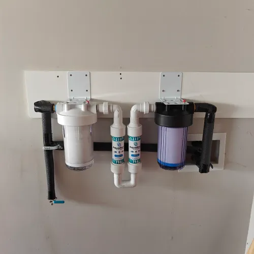 A water filter system is hanging on a wall | The Duke Of Plumbing