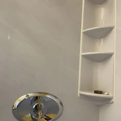 A bathroom with a shower head and a shelf | The Duke Of Plumbing
