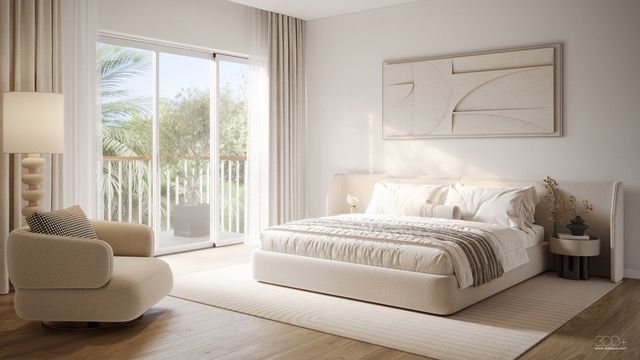Bright minimalist bedroom with a large bed, cream chair, and sliding doors opening to a sunny patio