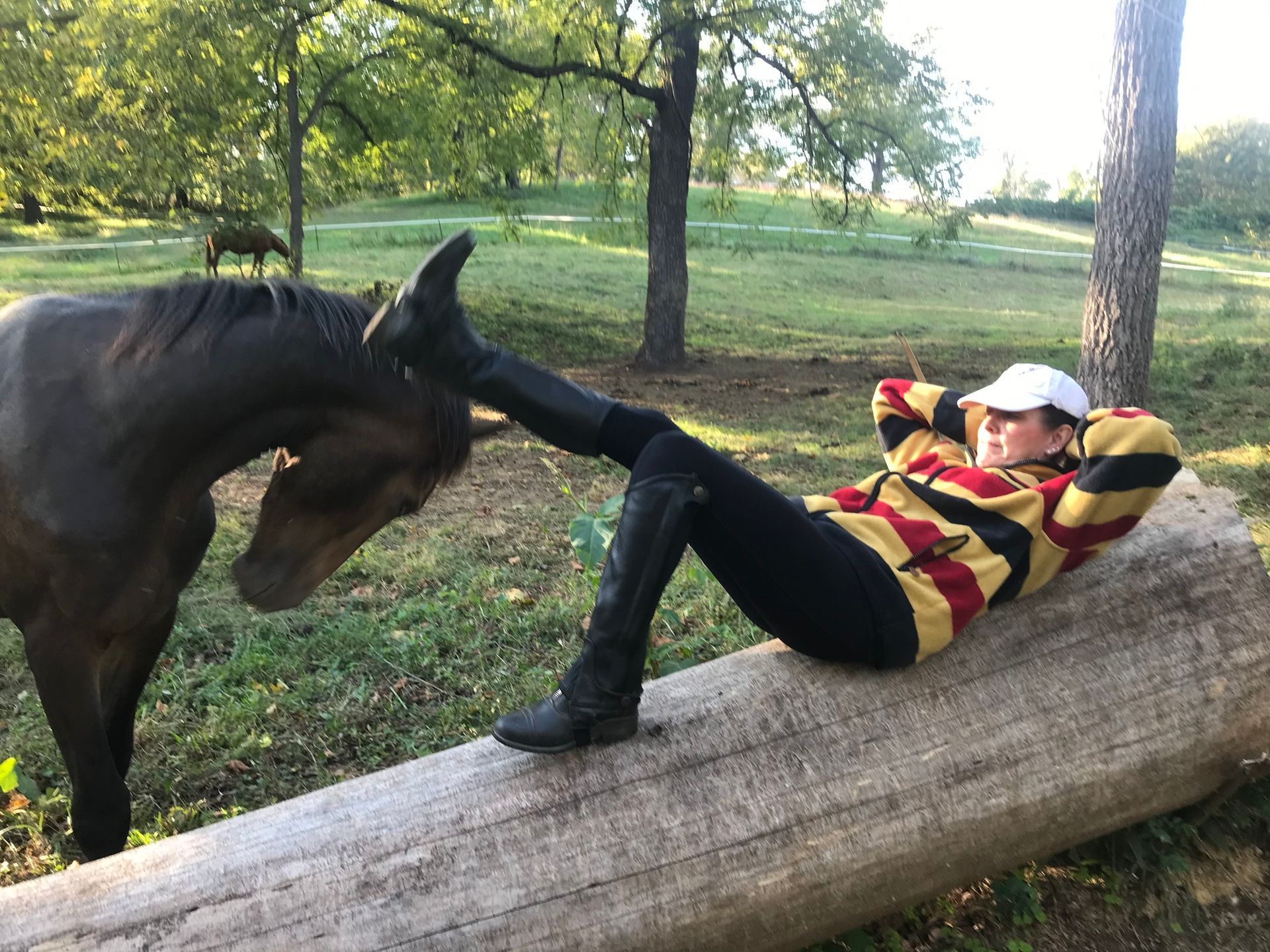 Woman laying in field with horse