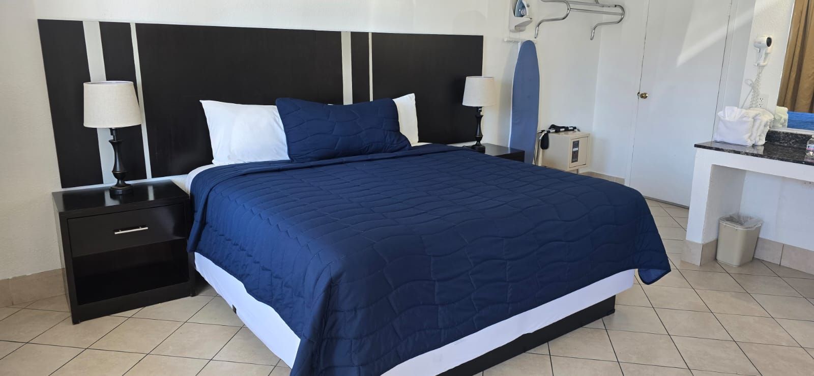 A hotel room with a king size bed and two nightstands.