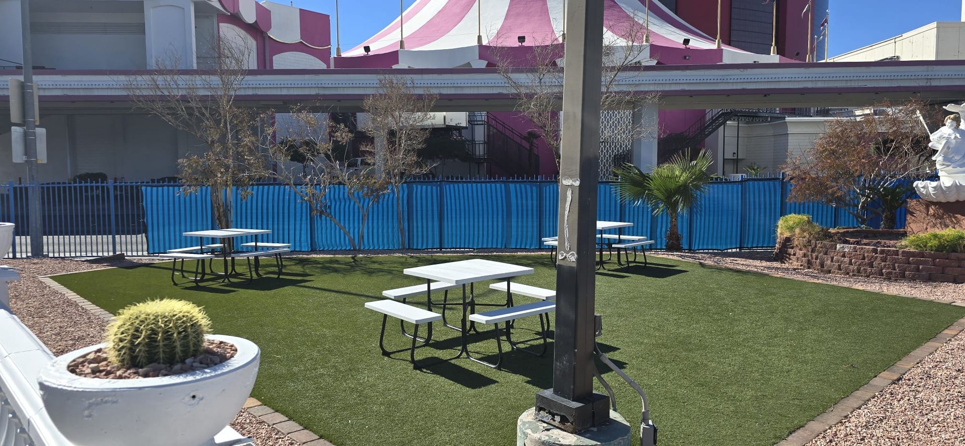 A picnic area with tables and benches in front of a building.