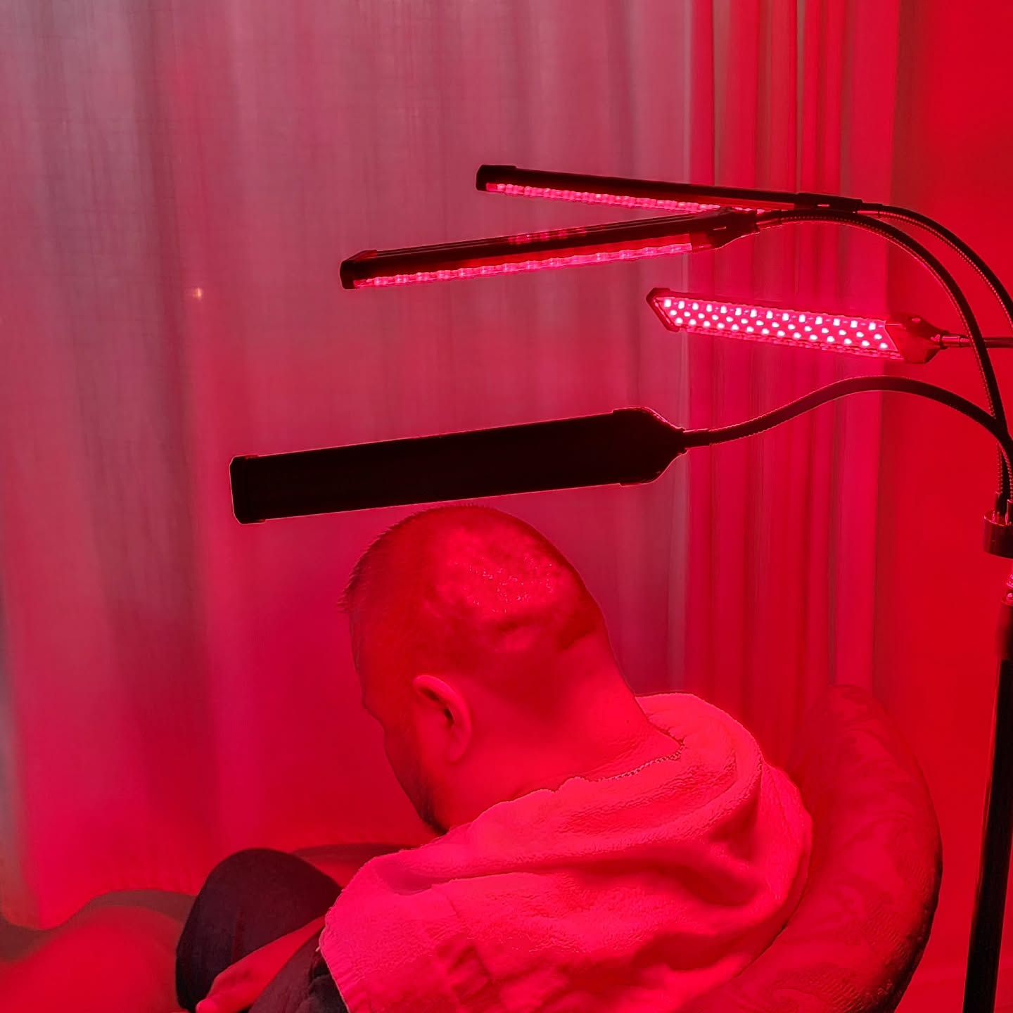 A man is sitting in front of a red light.