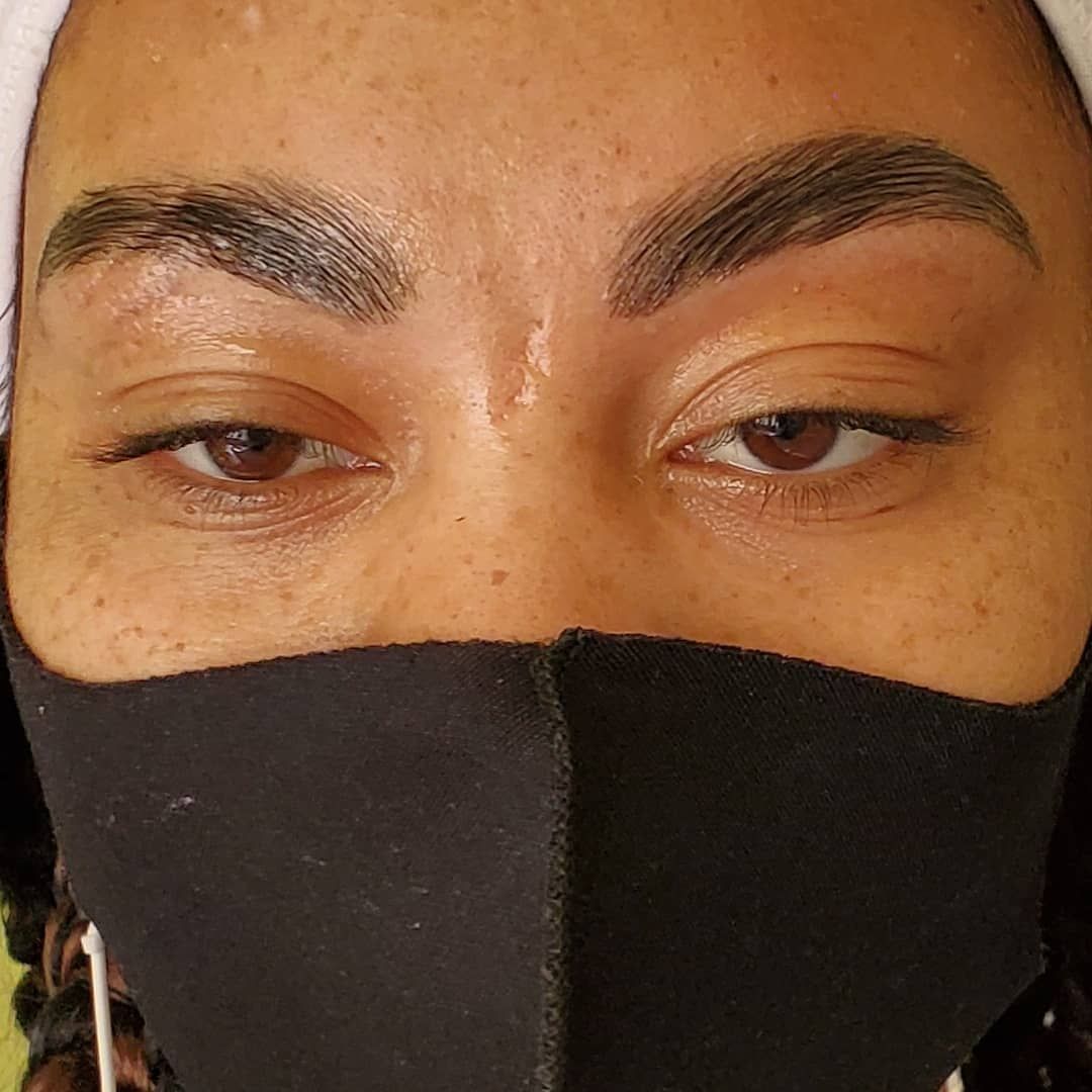 A close up of a woman wearing a black face mask.