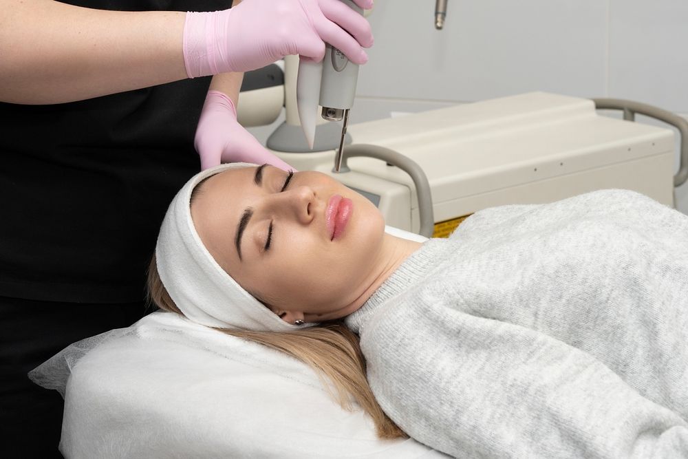 A woman is getting a laser treatment on her face.