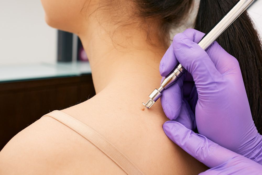 A woman is getting a laser treatment on her neck.