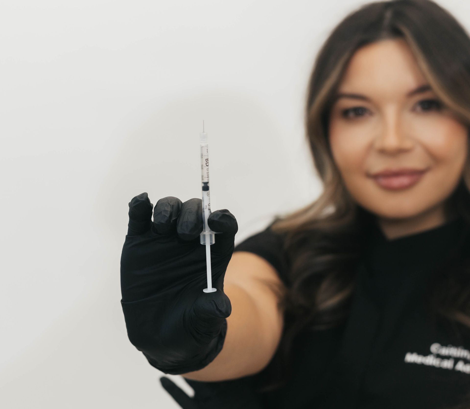 A person holding a bottle of insulin and a syringe