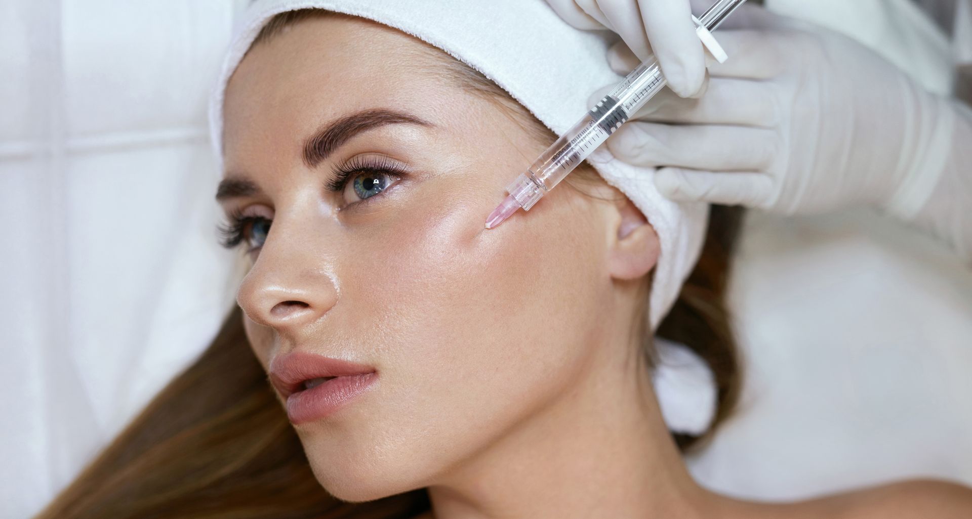 A woman is getting a botox injection in her face.
