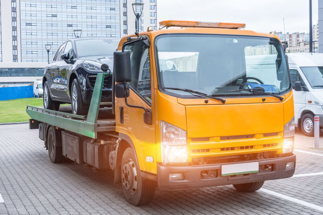 A tow truck with a car in the back - Hialeah, FL - Servicio De Gruas Towing Services