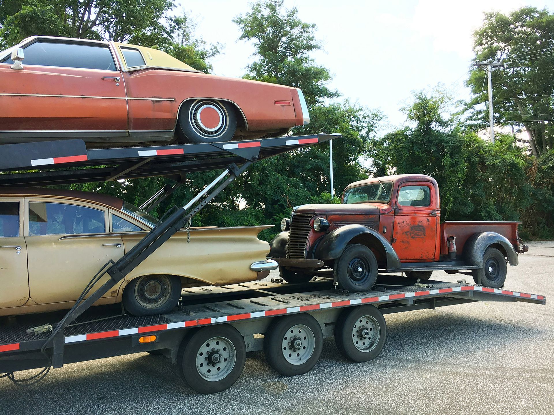 Two old cars are sitting on top of a trailer - Hialeah, FL - Servicio De Gruas Towing Services