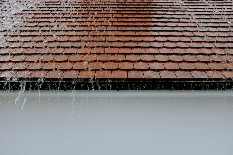 The rain is falling on the roof of a house.