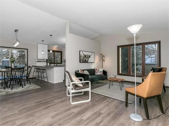 A living room with a couch and chairs and a lamp