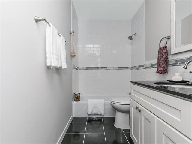 A bathroom with a toilet , sink and bathtub