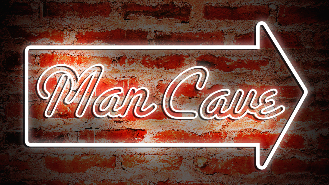 A neon sign on a brick wall that says Man cave - basement man cave ideas