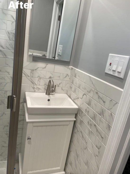 A bathroom with a sink , mirror and shower.
