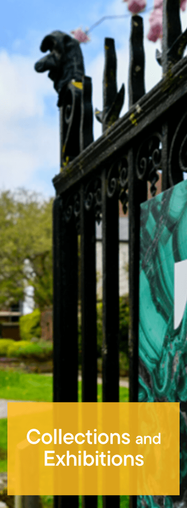 Black wrought iron gate with a gargoyle and a sign that reads 