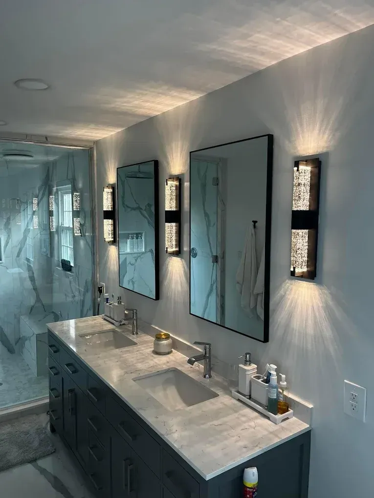 Bathroom with double vanity, two mirrors, and decorative lighting.