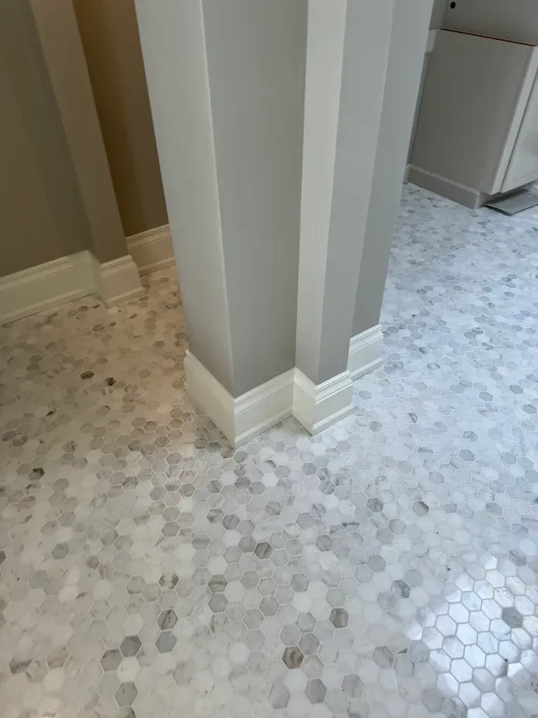 Light gray column with white trim on a hexagonal tile floor.