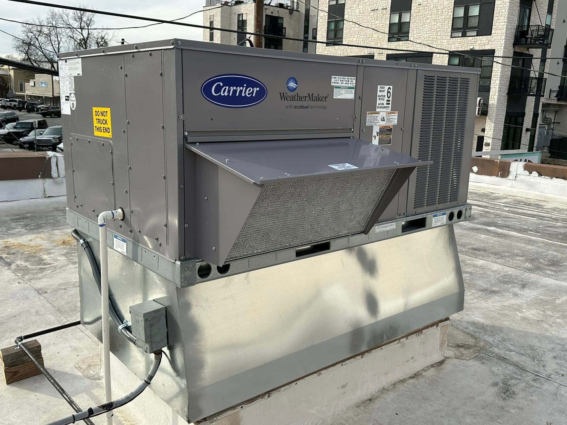 Carrier rooftop HVAC unit on a building with snow on the roof.