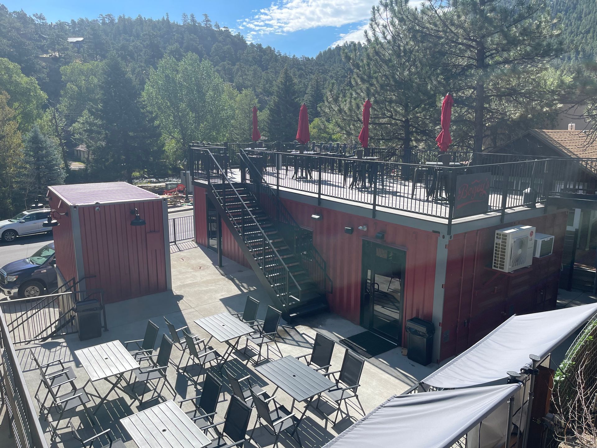 A red building with tables and chairs on the roof
