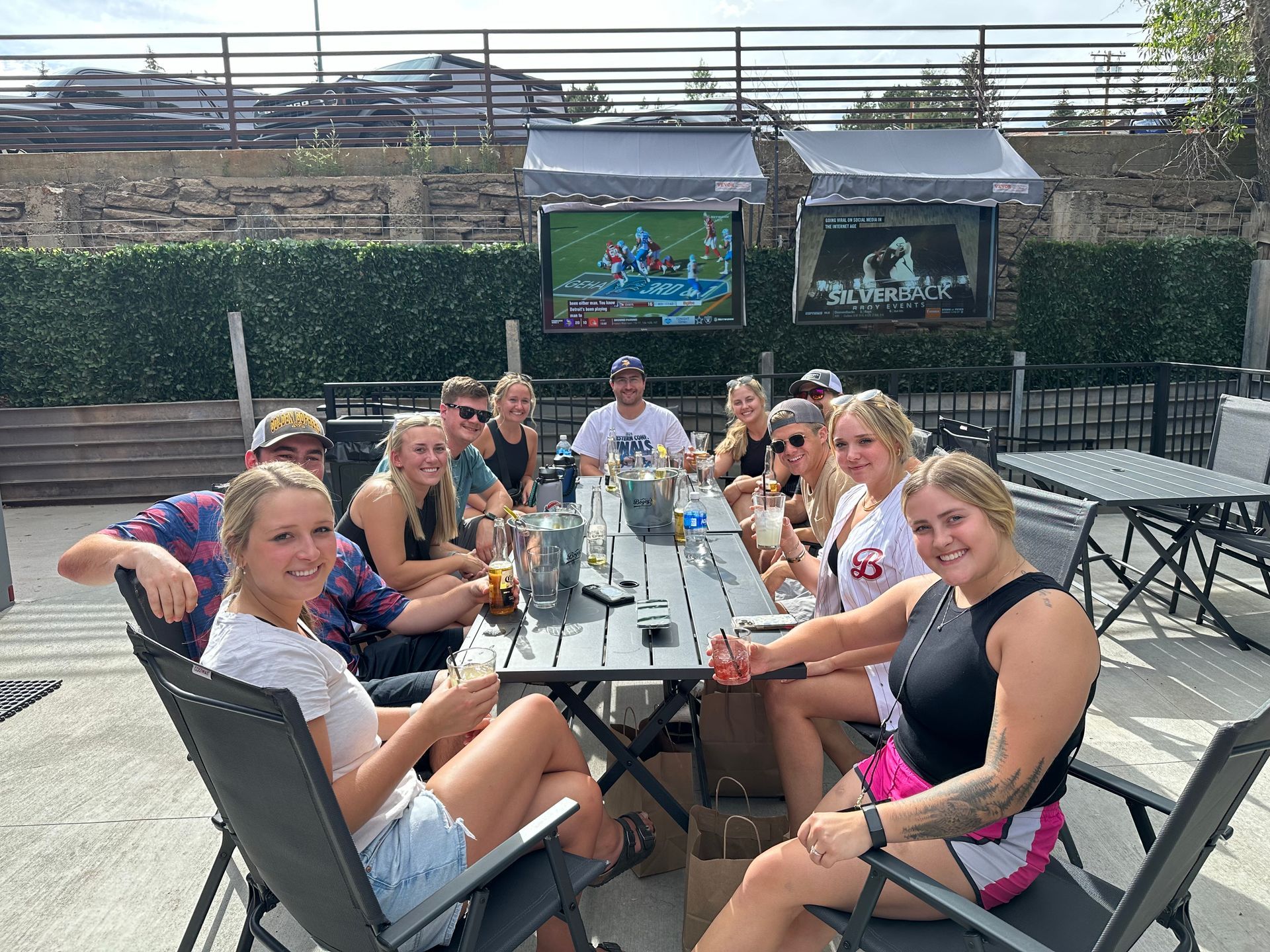 A group of people are sitting at a table outside.