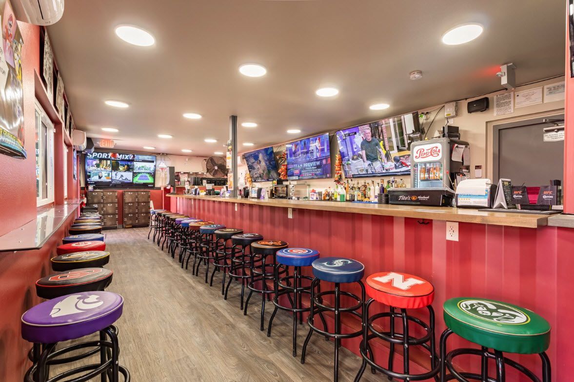 A long row of bar stools are lined up in a restaurant.