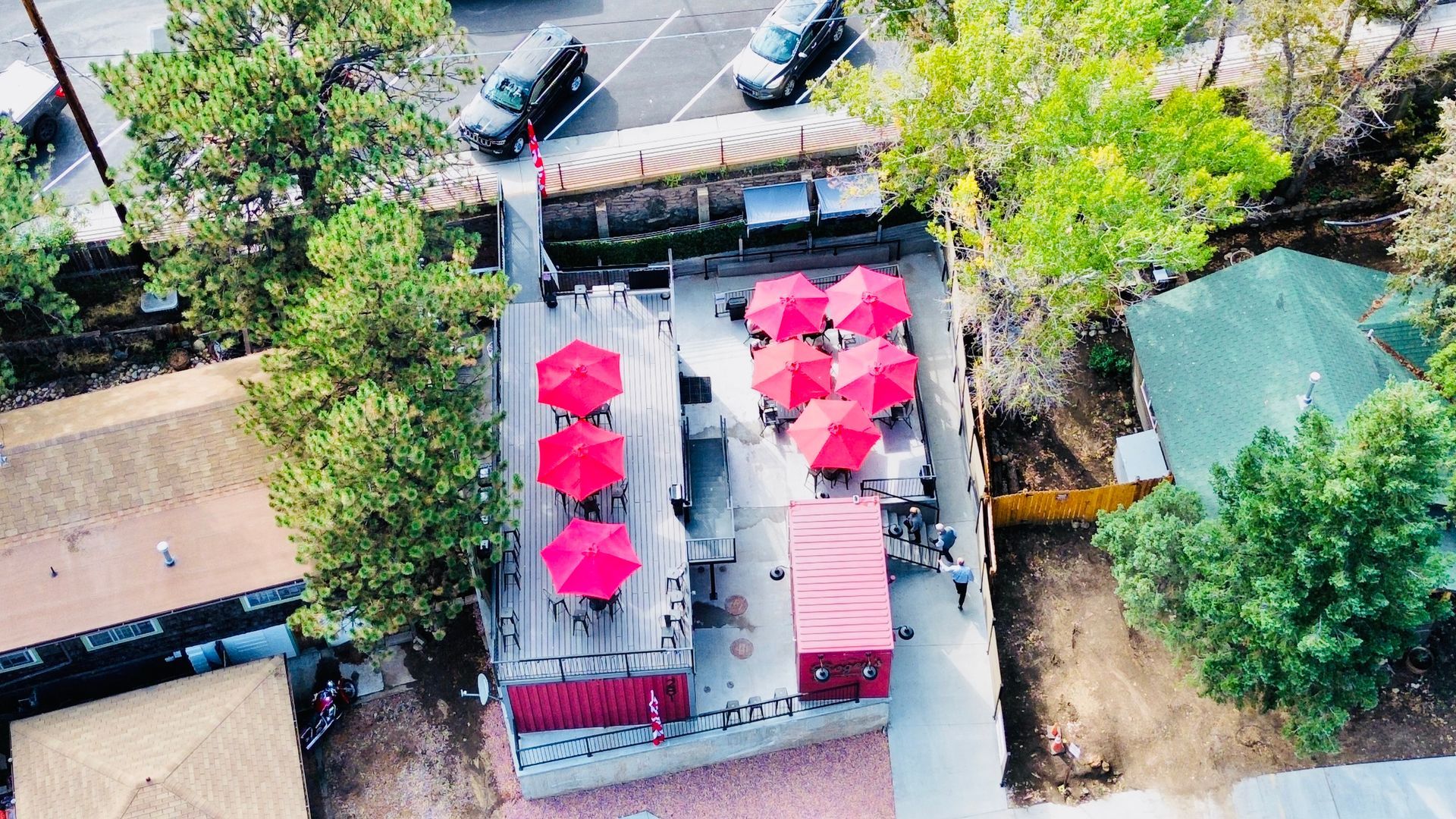 An aerial view of a restaurant with red umbrellas
