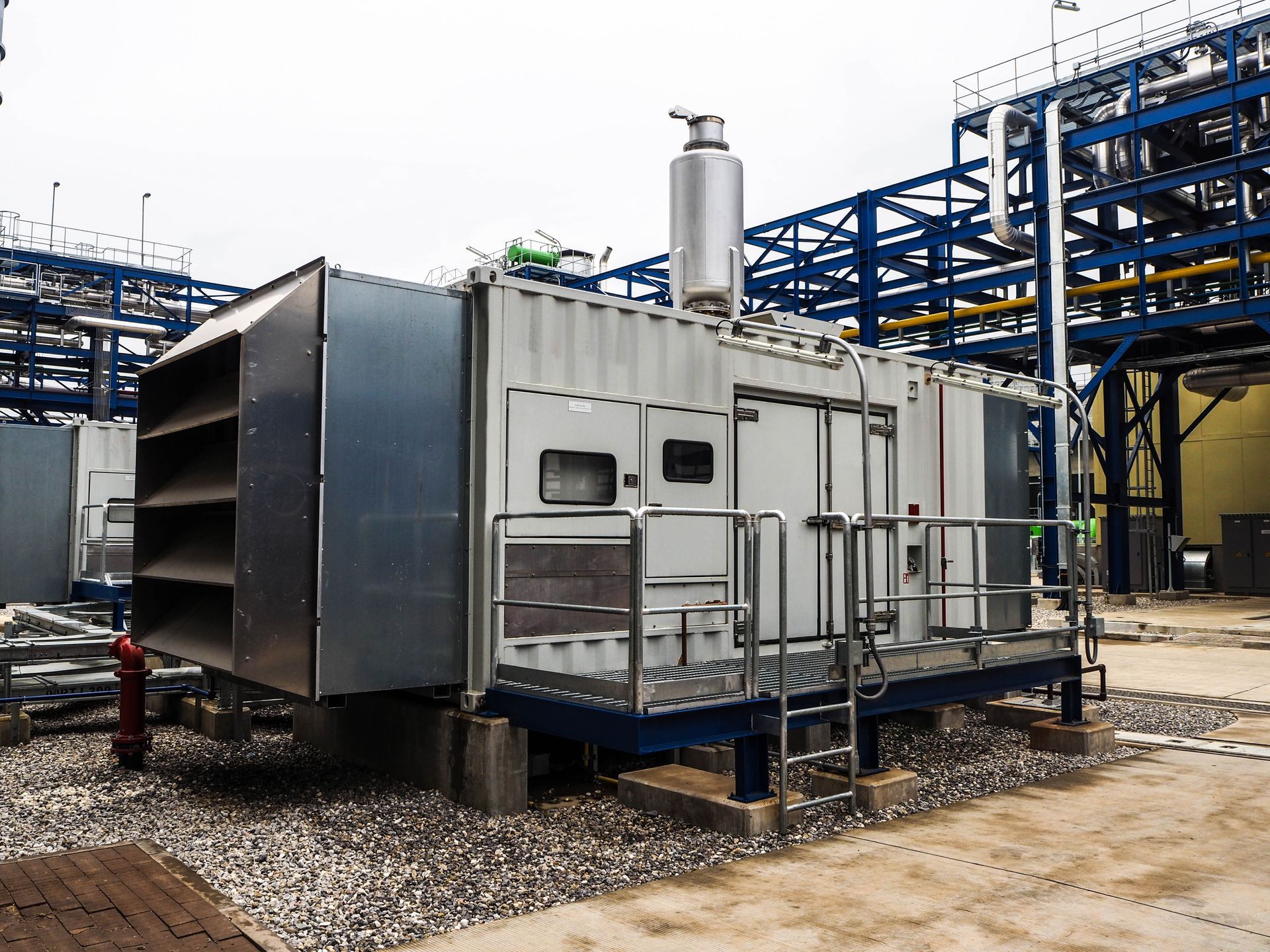 A large machine is sitting outside of a building.