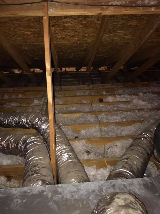 There are many ducts in the attic of a house.