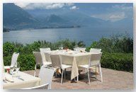 una terrazza di un ristorante con dei tavoli e vista di un lago