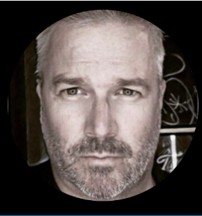 A man with a beard is looking at the camera