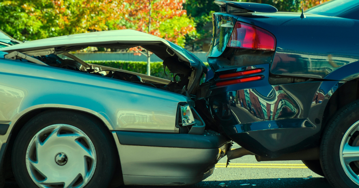 Two cars are involved in a car accident on the side of the road.