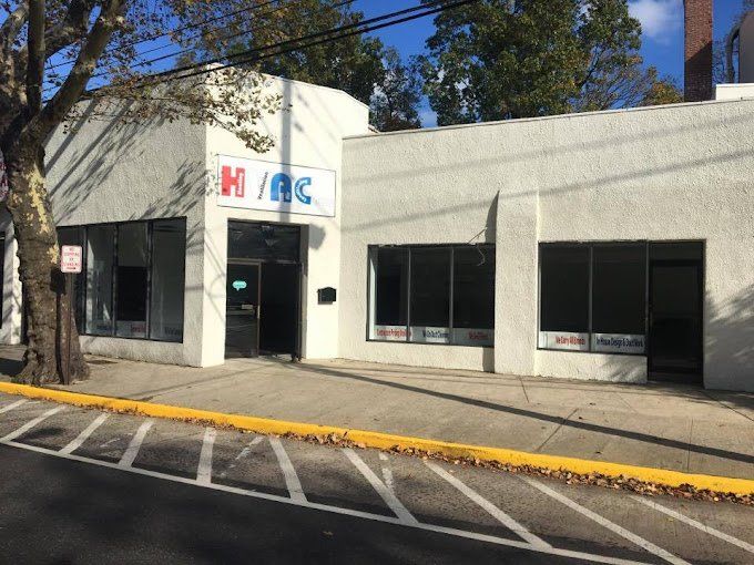 Exterior of a white commercial building with large windows and a sign that reads 