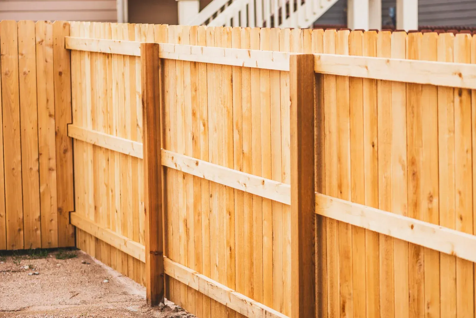 A wooden fence is sitting in front of a house.