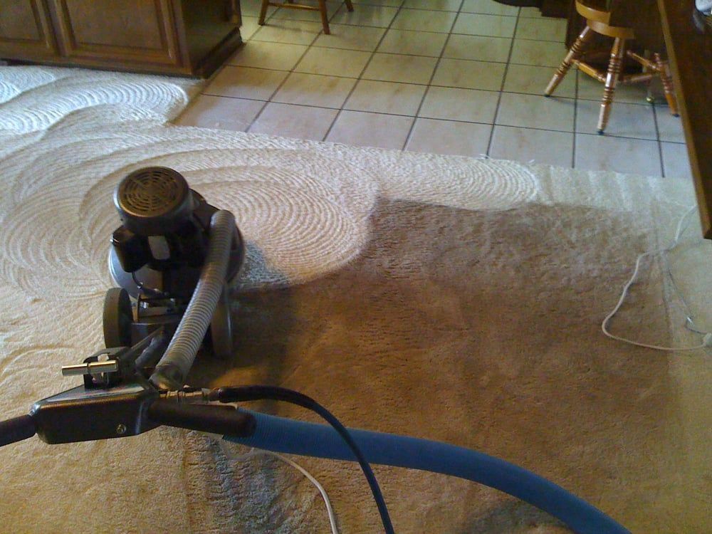A vacuum cleaner is sitting on a rug in a kitchen