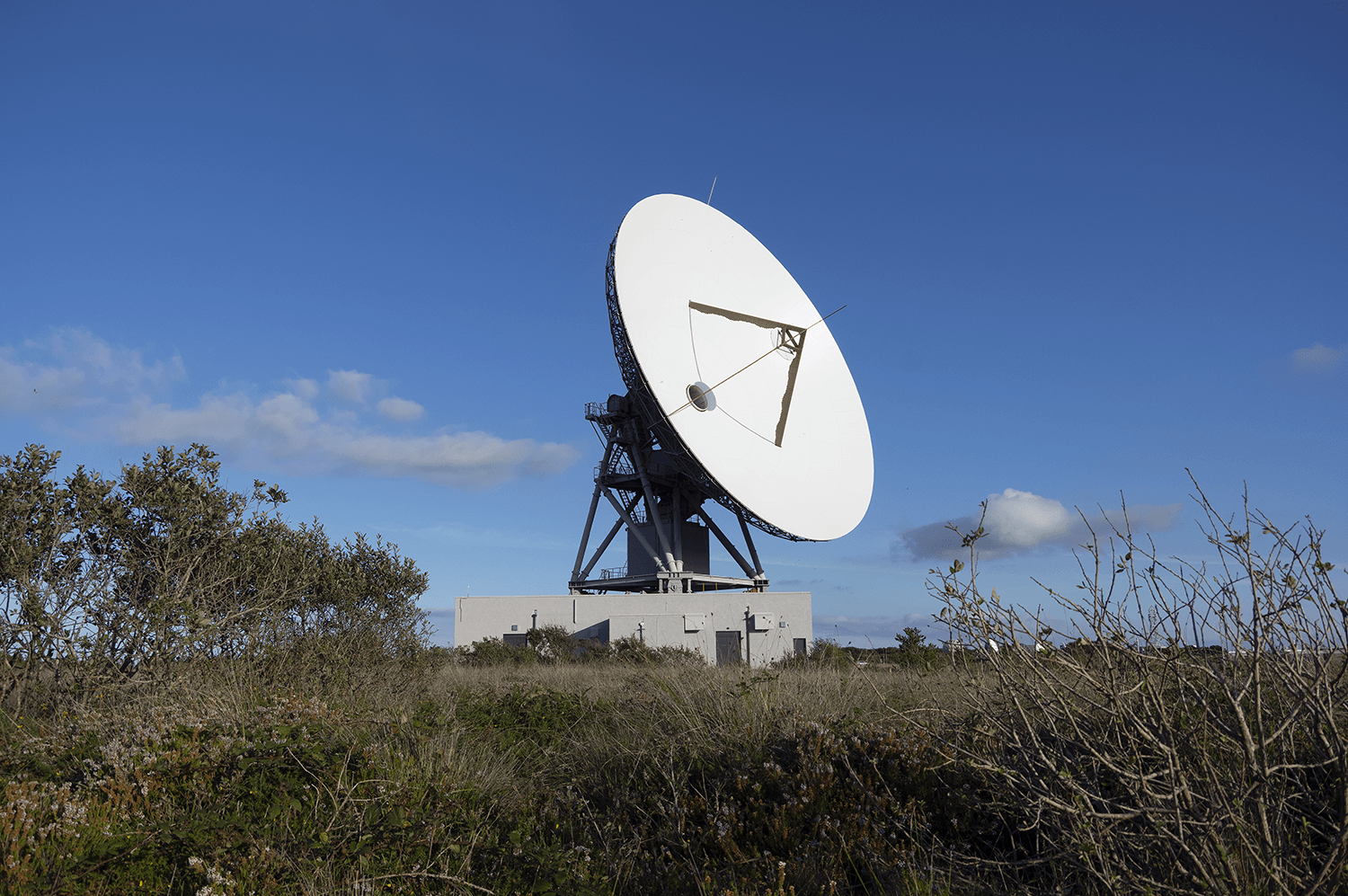 The 32 GHY-6 Deep Space Antenna looks skyward against a bright blue sky