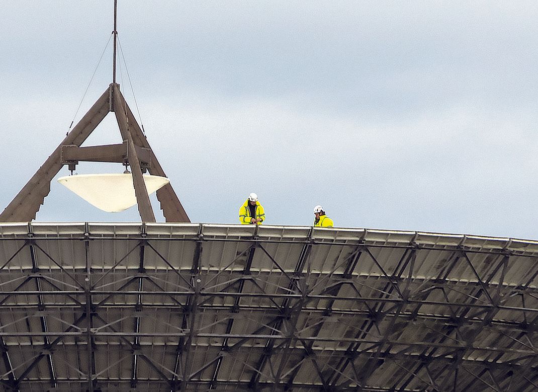 Scientist discusses wave form analysis to group of visiting guests