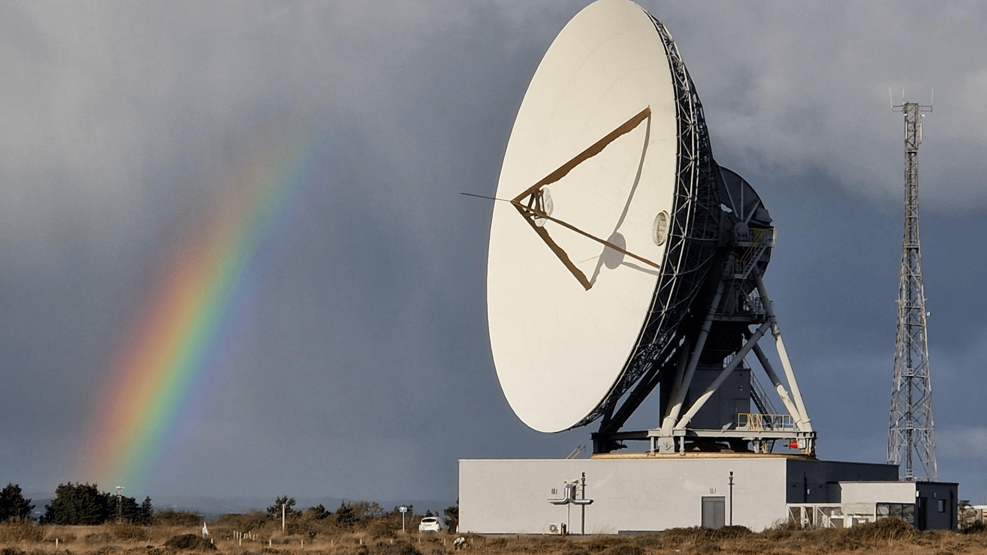 32m GHY-6 antenna, used for lunar and deep space communications, is pointing towards its target, with a rainbow next to it.