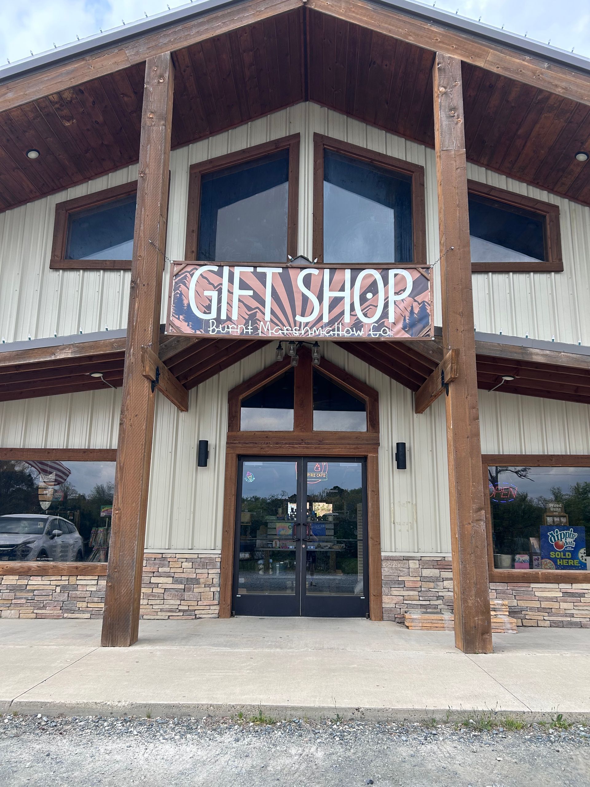 Gift shop entrance with rustic wood beams and stone facade under a peaked roof