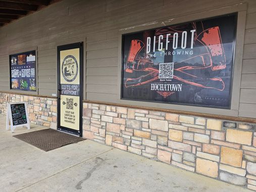 Storefront with Bigfoot Brewery sign, stone half-wall, and glass door under an awning.