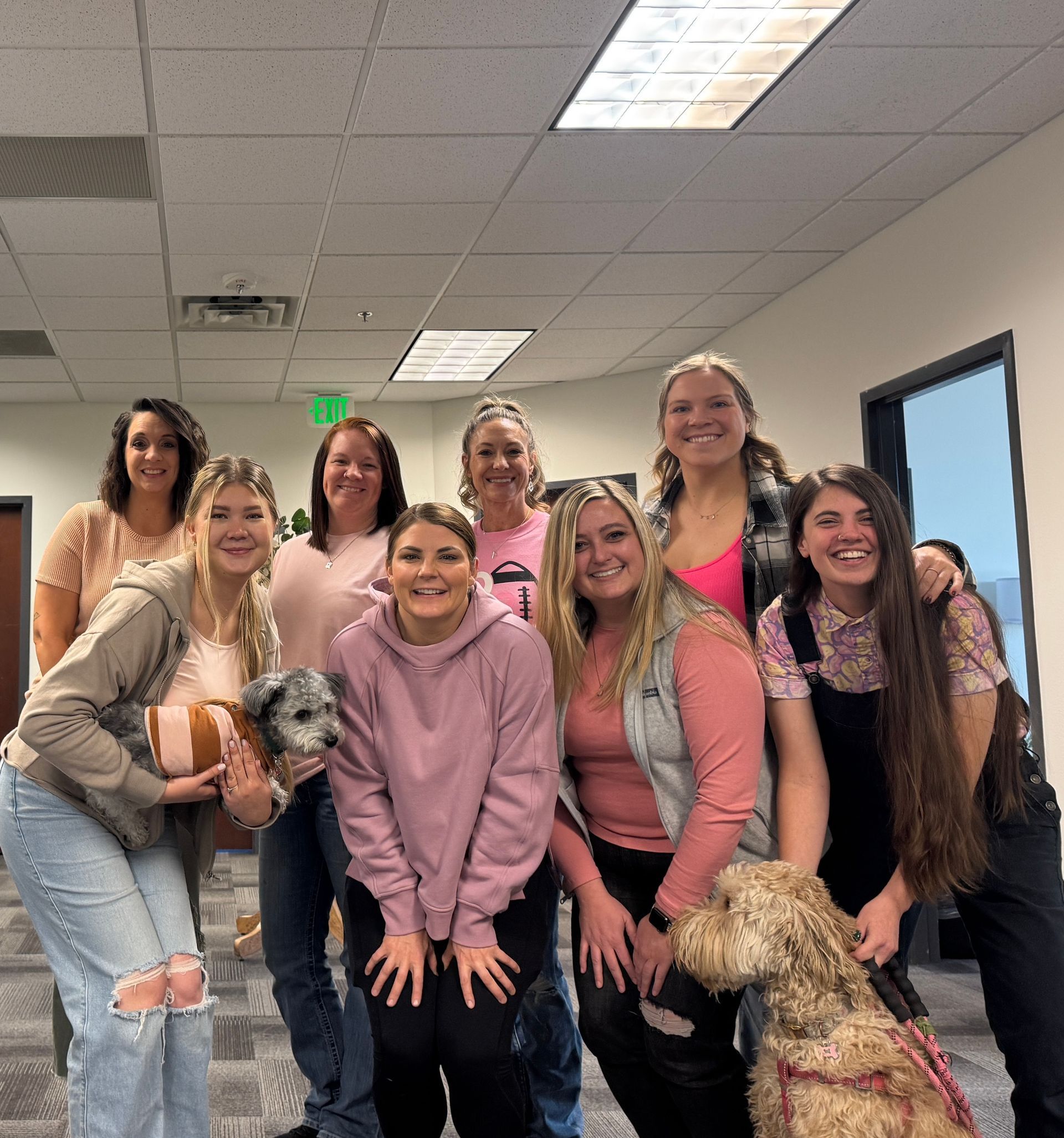 A group of women are posing for a picture with their dogs.