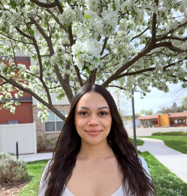 A young man in a blue shirt is smiling for the camera.