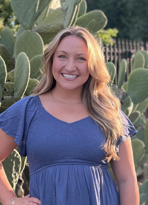 A young man in a blue shirt is smiling for the camera.