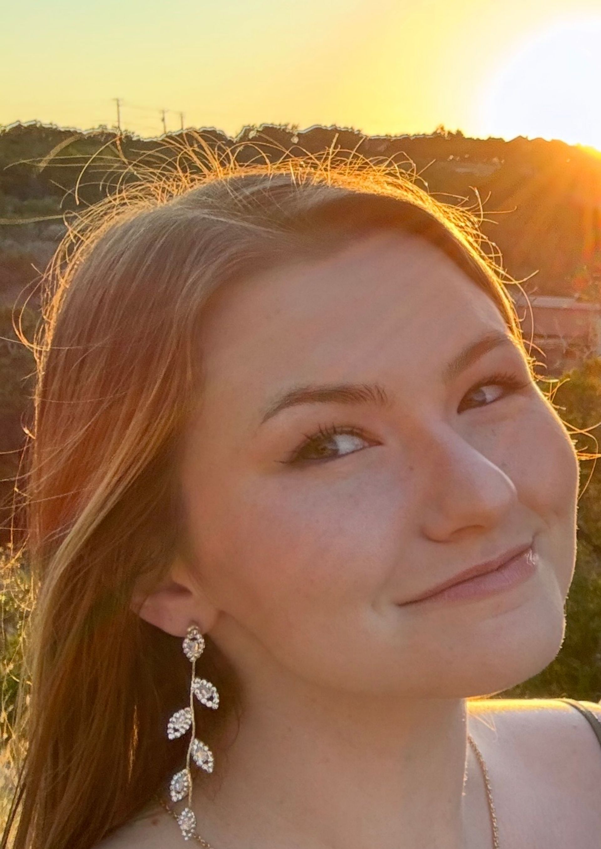 A man in a black shirt is standing in front of a tree.