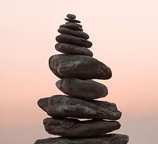 A stack of rocks stacked on top of each other on a pink background.