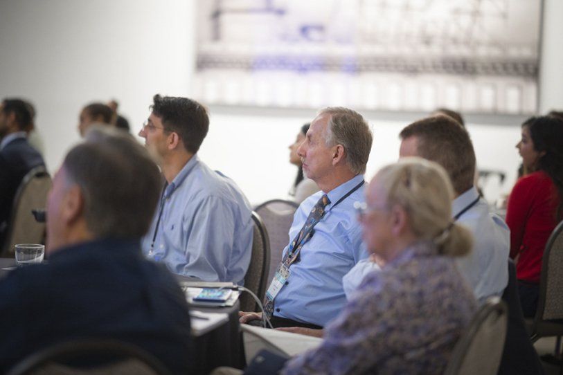 A group of people are sitting in a room watching a presentation.