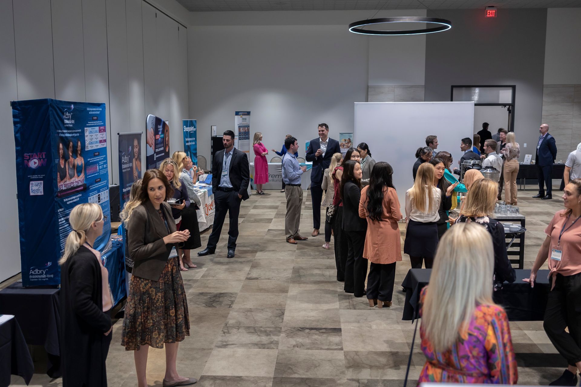 A group of people are standing in a room talking to each other.