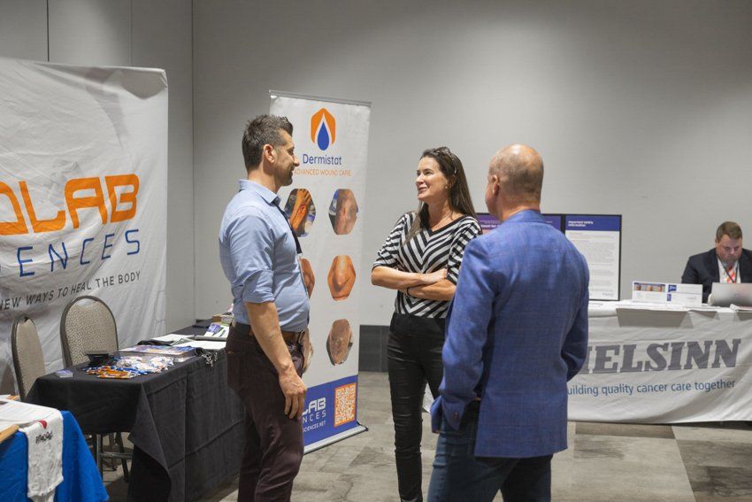 A group of people are standing in a room talking to each other.