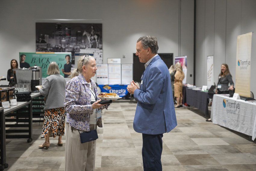 A man and a woman are standing in a room talking to each other.