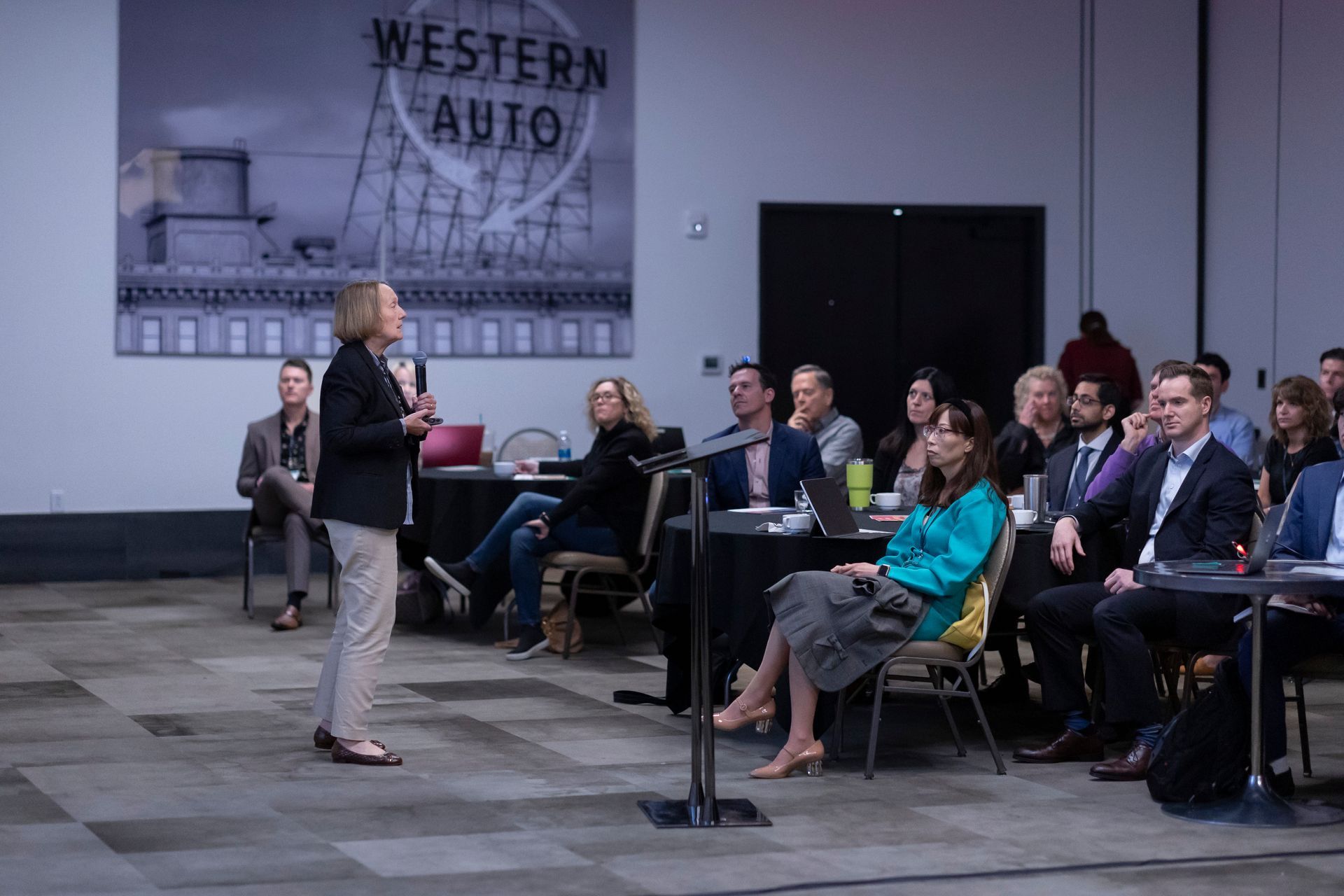 A woman is giving a presentation to a group of people in a conference room.